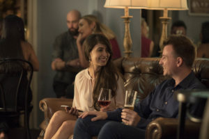 Man and woman sitting together on a sofa and chatting after meeting at a speed dating event.