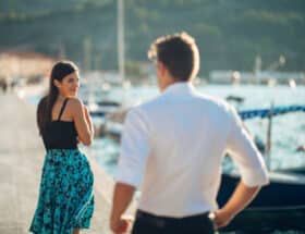 Attractive young woman looking back over her shoulder at a man.