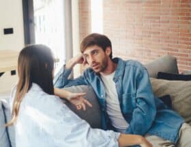 Man and woman talking on the sofa.