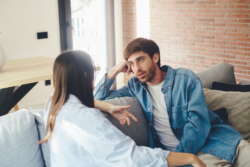 Man and woman talking on the sofa.