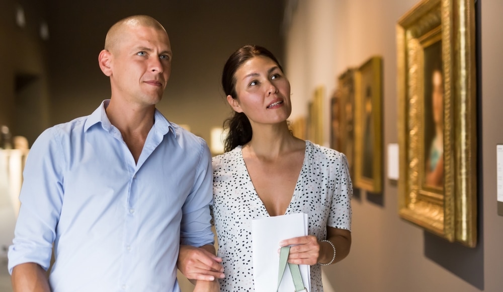 A couple strolling through an art museum.