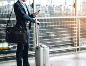 Business man in airport looking at cellphone