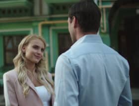 Blonde woman talking to a man in a blue shirt.